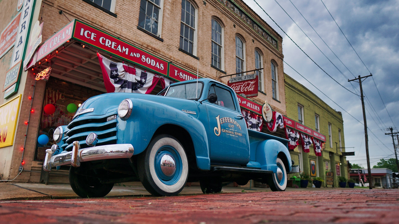 Blue Vintage Car in Front of Brown Building